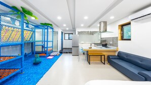 A modern apartment with a kitchen, dining area, and a play area for children. - Gapyeong Himong Aegyeon Kids Pension (Gapyeong)