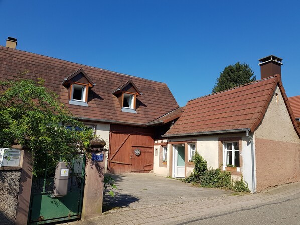 A traditional European-style building with a brown tiled roof, a wooden door, and a small window. - Detached outbuilding. (COSSWILLER)