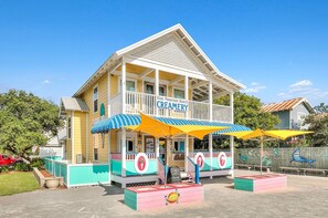 A creamery with a two-story structure, a covered porch, and colorful awnings. - Golf Cart | Pool | Gym | South of 30a (Santa Rosa Beach)