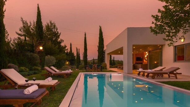 A modern outdoor pool area with lounge chairs and a clear view of the pool.