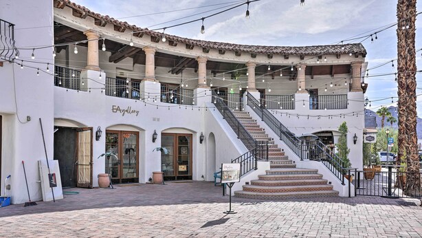 A building with a gallery on the ground floor, a staircase leading to an upper level, and a paved courtyard. - Lavish 3 BR La Quinta Oasis < 2 Mi to Old Town (La Quinta)