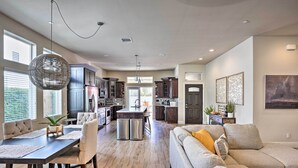 A spacious living area with a large sofa, dining table, and kitchen in the background. - Lavish 3 BR La Quinta Oasis < 2 Mi to Old Town (La Quinta)