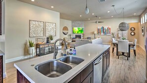 A modern kitchen with a large island, double sink, and contemporary lighting fixtures. - Lavish 3 BR La Quinta Oasis < 2 Mi to Old Town (La Quinta)