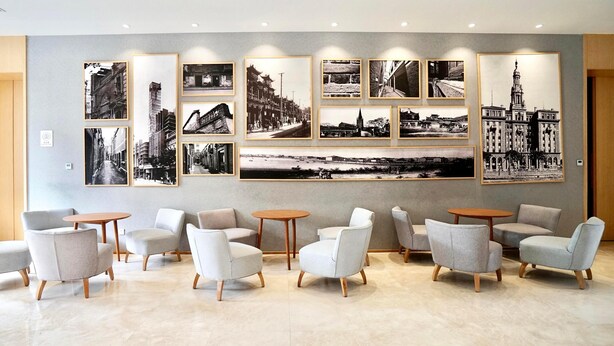 A hotel lobby with multiple seating areas, a large wall of black and white photographs, and a modern design. - Ji Hotel Shanghai Oriental Pearl Tower (Shanghai)
