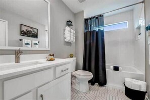 Bathtub, hair dryer, towels, shampoo