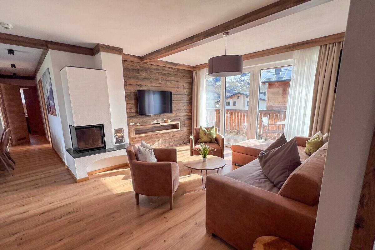 A modern living room with a fireplace, a television, and a sofa.