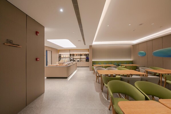 Un espace repas moderne doté d’un comptoir central, de sièges et offrant une vue sur la cuisine.