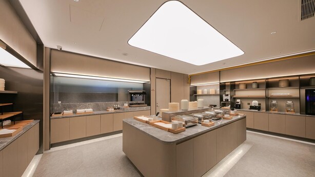 Ett modernt kök med en central köksö, inbyggda vitvaror och en stilren design.