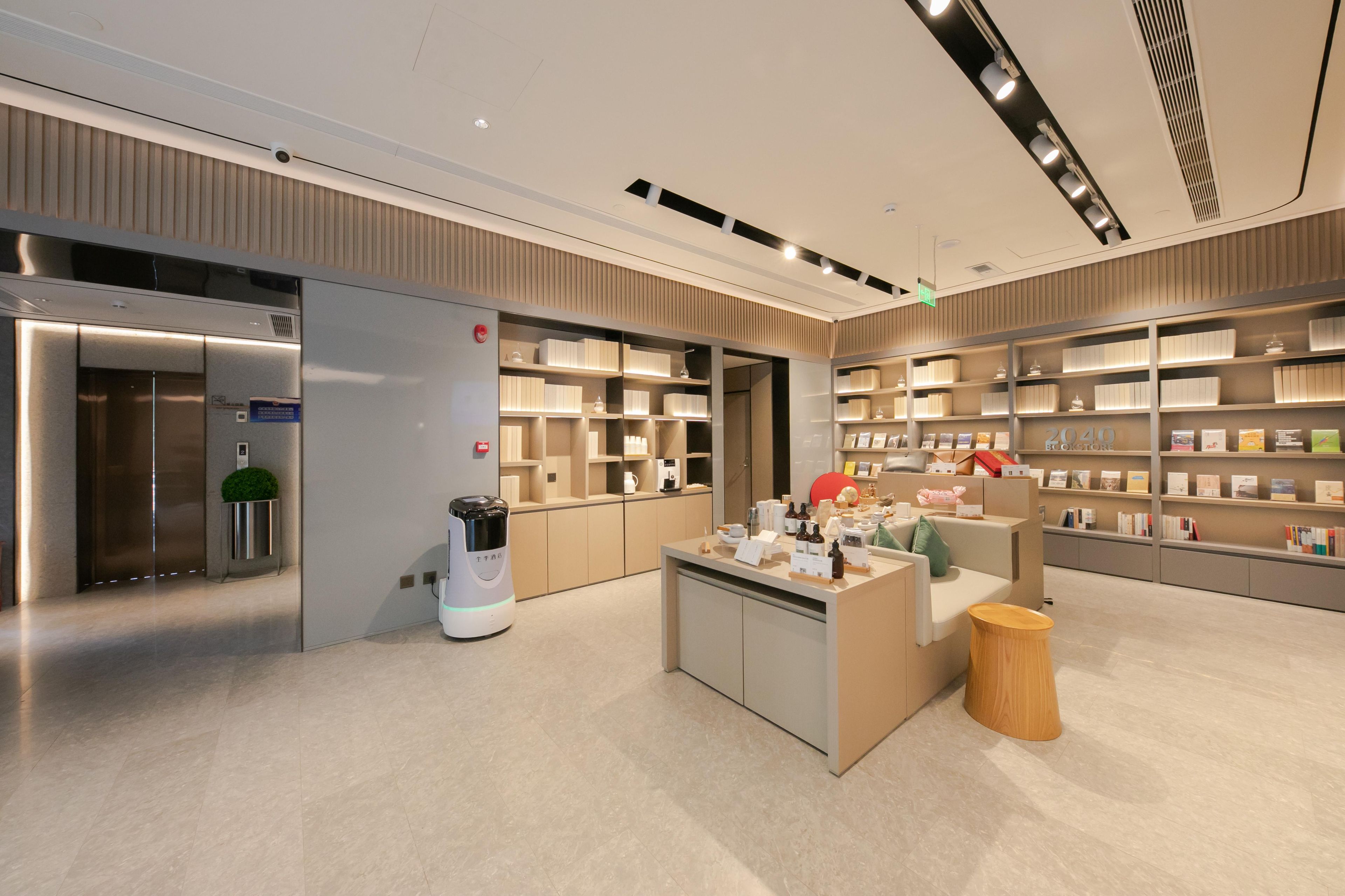 Un interior moderno con un mostrador de recepción, estantes con productos y una máquina de café.