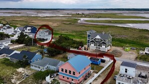 Una zona residencial costera con casas, una calle y una masa de agua al fondo.