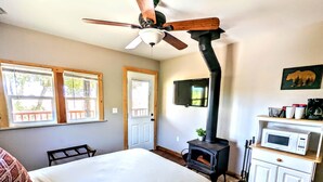 A bedroom with a bed, a ceiling fan, a fireplace, a TV, and a microwave on a cabinet. - # 3. Howling Wolf's Lair - Studio W/ Fireplace (Pet Free) (Santa Ysabel)