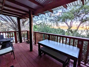 A covered outdoor area with a wooden bench and a table, surrounded by trees and a view of a body of water. - # 3. Howling Wolf's Lair - Studio W/ Fireplace (Pet Free) (Santa Ysabel)
