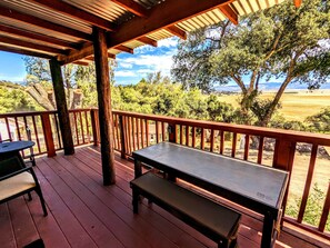 A wooden deck with a table and bench, overlooking a scenic landscape with trees and a distant view. - # 3. Howling Wolf's Lair - Studio W/ Fireplace (Pet Free) (Santa Ysabel)