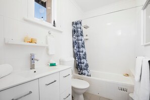 Bathtub, rainfall showerhead, hair dryer, towels