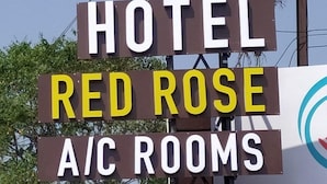 A sign for a hotel named 'Red Rose' with 'A/C Rooms' indicated. - Hotel Red Rose (Vadodara)