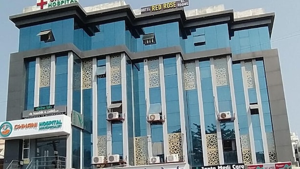 A multi-story building with signs for CHHANI HOSPITAL, HOTEL RED ROSE, and JANTA MEDI CARE. - Hotel Red Rose (Vadodara)