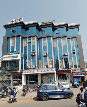 A multi-story building with signs for CHHANI HOSPITAL, HOTEL RED ROSE, and JANTA MEDI CARE. - Hotel Red Rose (Vadodara)