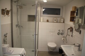 Een douche, een haardroger, handdoeken, toiletpapier