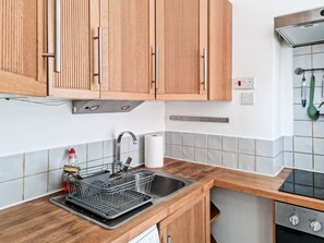 Enjoy cooking in this well-equipped kitchen with an oven, stainless steel sink, and ample countertop space.