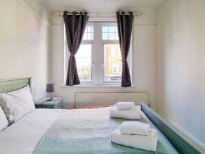 Relax in a serene space with a comfortable bed, crisp linens, and a cozy throw blanket.