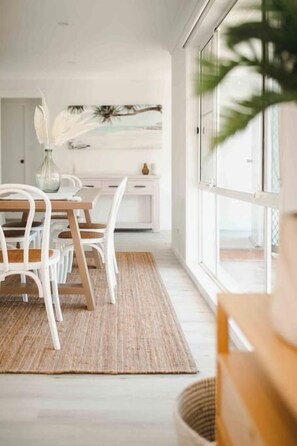 Un espace repas comprenant une table, des chaises et un tapis.