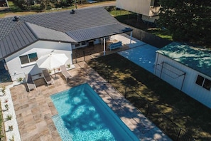 A modern house with a swimming pool, covered patio, and a fenced backyard. - Seagrass (Culburra Beach)
