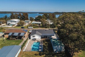 Zona residencial com casas, piscina e vista para um lago.