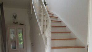 Una escalera con escalones de madera y barandillas blancas.