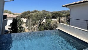 A swimming pool with a clear blue sky in the background, surrounded by buildings and trees. - Magnificent villa with private pool (monticello)