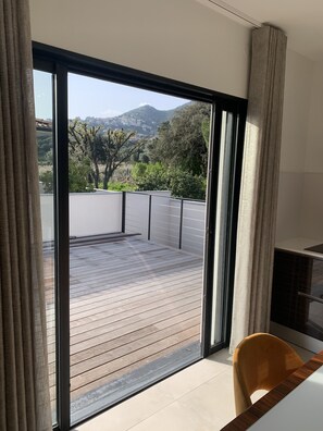 Ein modernes Zimmer mit einer großen Schiebeglas-Tür, die auf eine Holzterrasse führt.