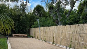 A landscaped garden with a gravel path, white pebbles, and a wooden deck.