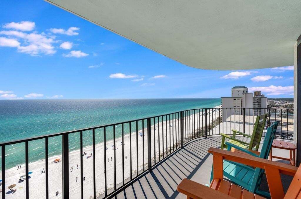 A balcony with a view of a beach and ocean.