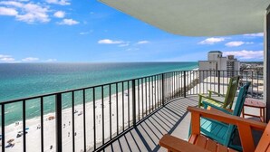 A balcony with a view of a beach and ocean.
