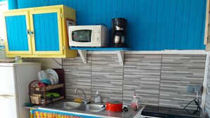 A compact kitchen with a microwave, coffee maker, and a small refrigerator. - Studio eliconia<br>Quartier anse bellune <br>Rue la bellune Trinité 97220 (trinite)