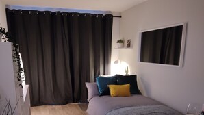 A modern bedroom with a bed, bedside table, and a desk with a chair. - Fantastic Centrally Located 1 bed Apartment (Liverpool)