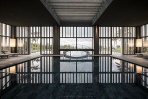 Piscine intérieure, piscine extérieure en saison, chaises longues