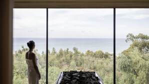 A room with a large window overlooking a natural landscape.