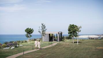 A pathway leading to a pavilion with a view of the ocean.