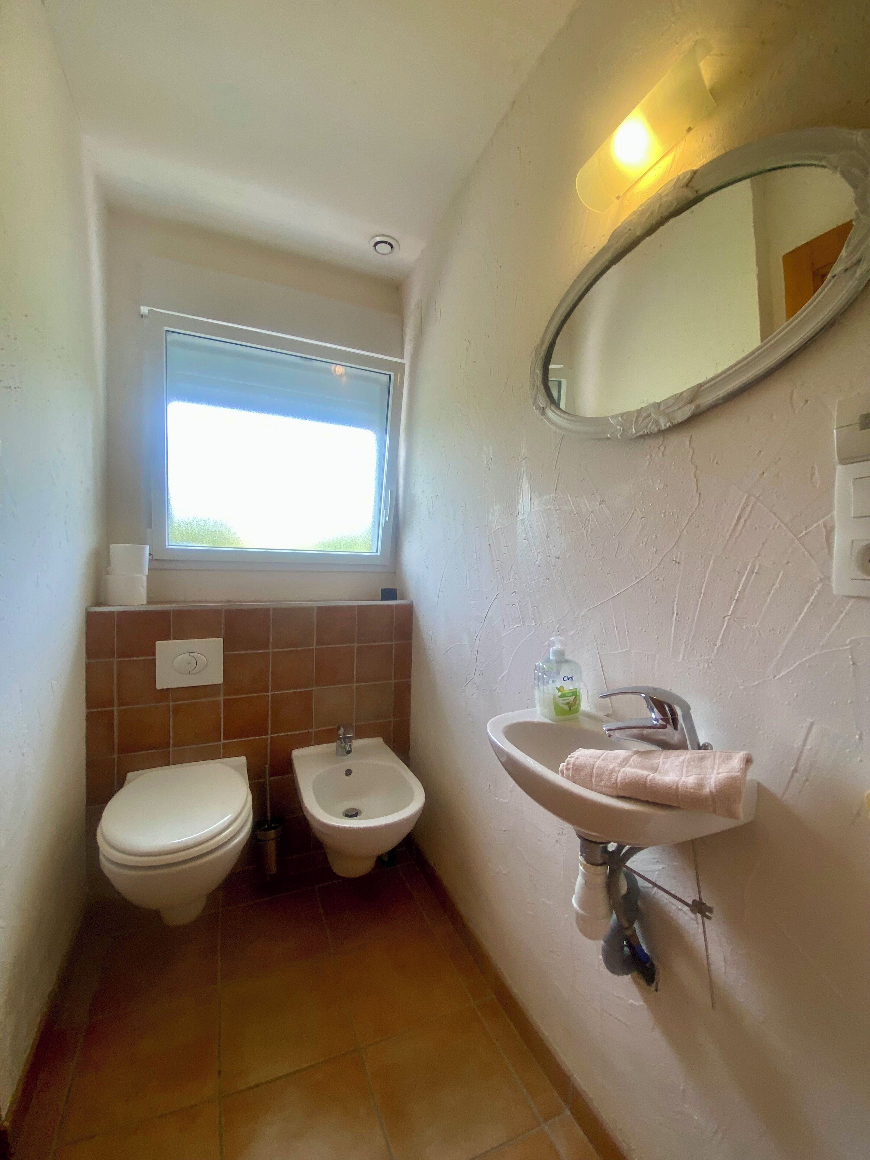 Une petite salle de bain comprenant des toilettes, un bidet et un lavabo.