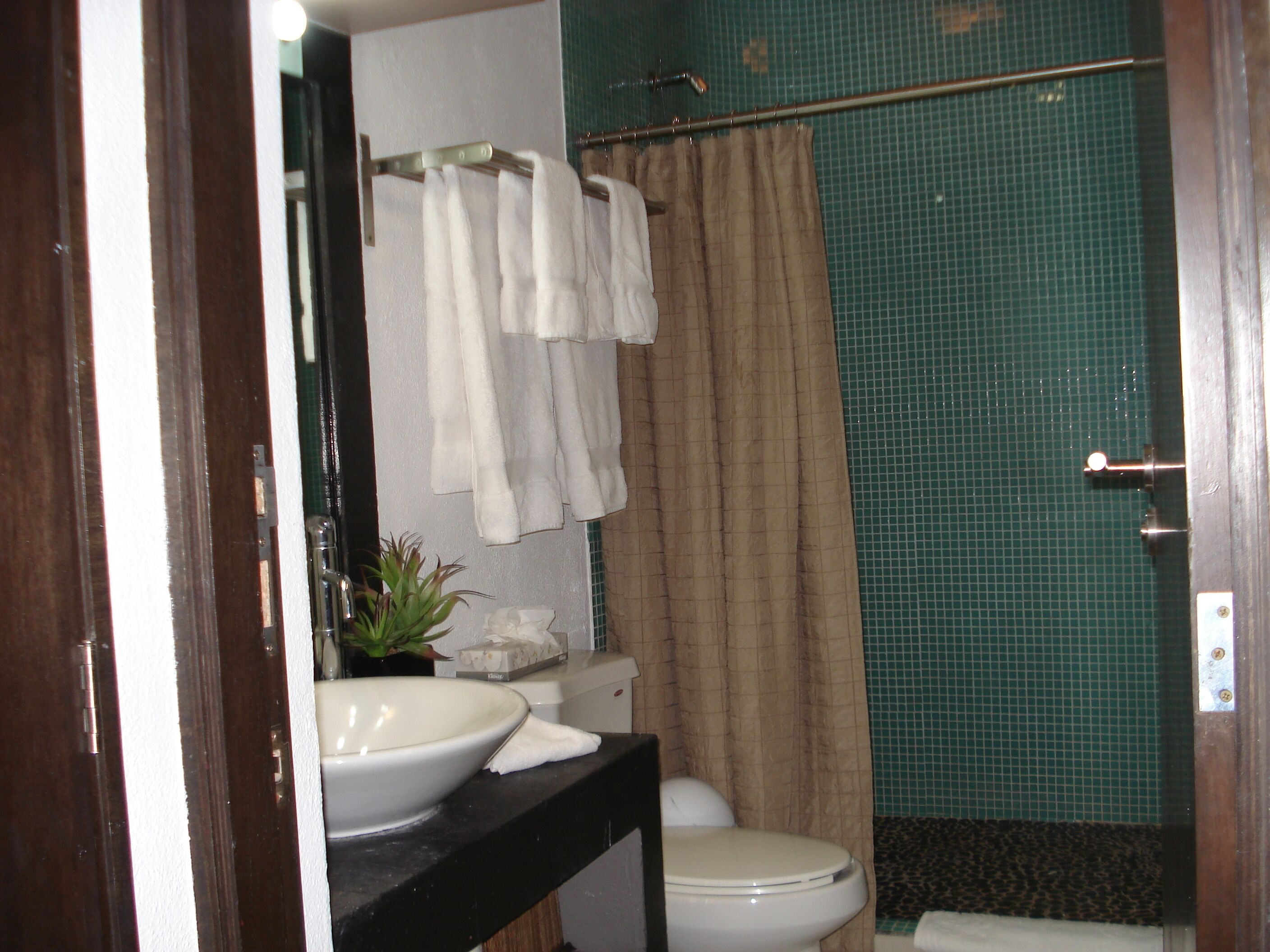 Un baño con lavamanos blanco, inodoro y cortina de ducha.