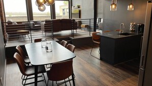 Une cuisine moderne avec un coin repas, de grandes fenêtres et une vue sur la ville.