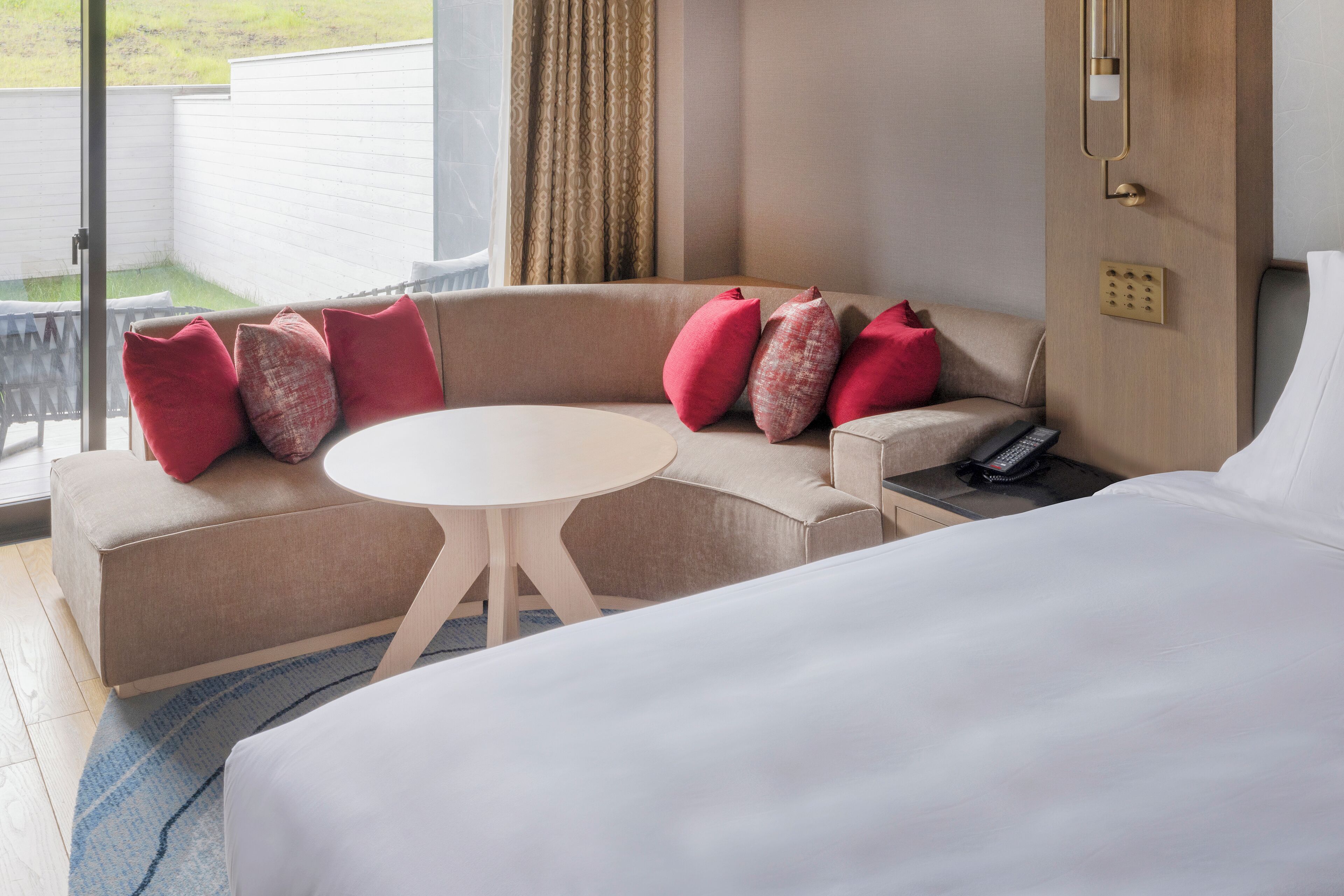 A hotel room with a sofa, a round table, and a bed.