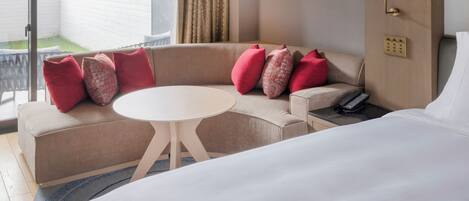 A hotel room with a sofa, a round table, and a bed.
