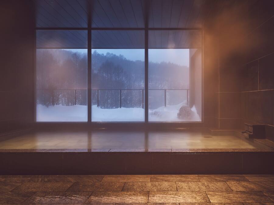 A room with a large window overlooking a snowy landscape.