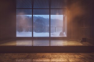 Una habitación con un ventanal grande con vistas a un paisaje nevado.