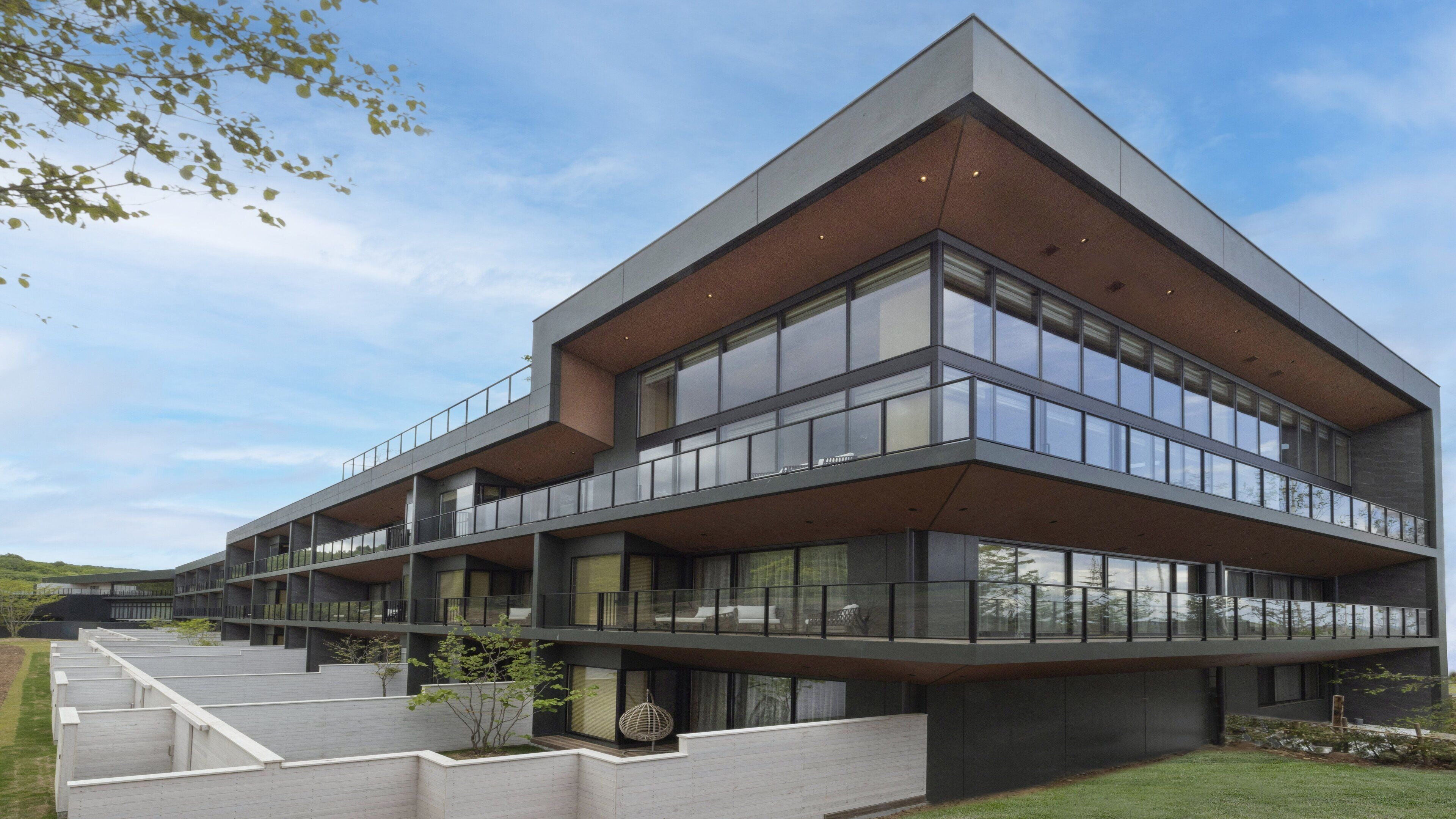 Un edificio moderno de varios pisos con ventanas amplias y balcones.