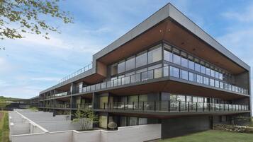 Un edificio moderno de varios pisos con ventanas amplias y balcones.