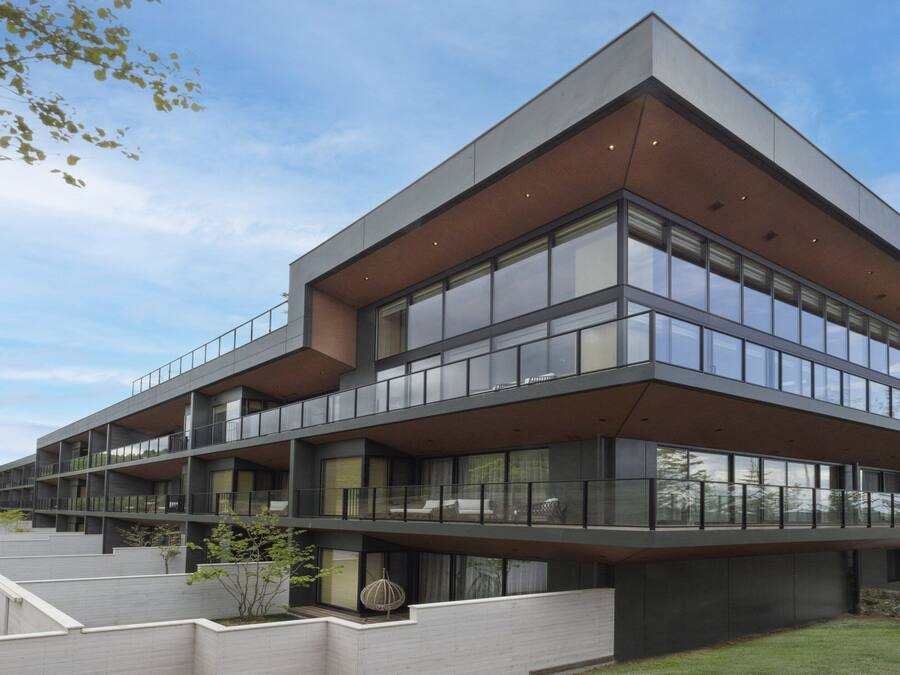 Un edificio moderno de varios pisos con ventanas amplias y balcones.