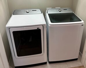 Two white Samsung front-loading washing machines in a corner. - Paradise Found at Lost Key Resort: Tropical Bliss (Pensacola)