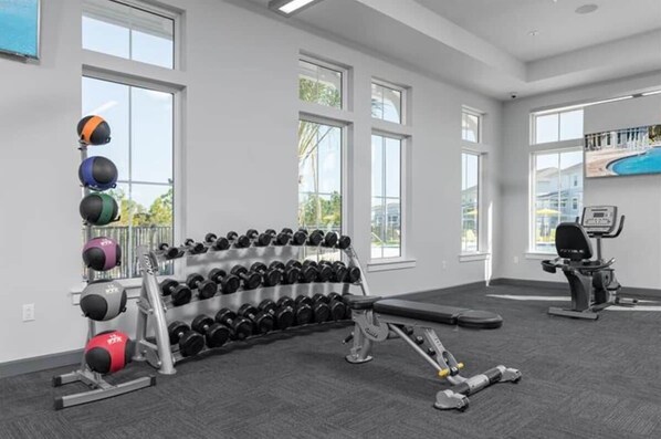 A gym with dumbbells, a bench, and exercise equipment.